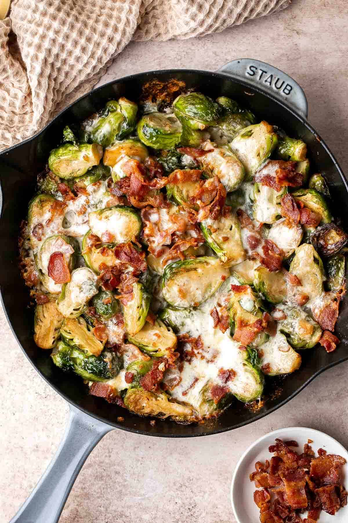 Cheesy Brussels Sprouts Bake is a comforting side dish made with sautéed garlic brussels sprouts, topped with bacon and cheese, and baked until bubbly. | aheadofthyme.com