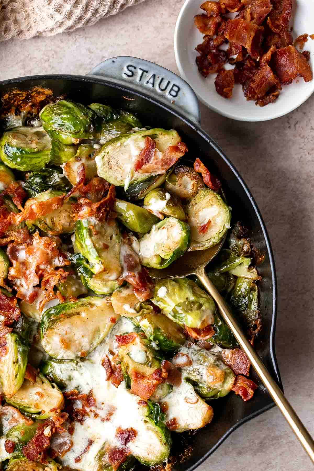 Cheesy Brussels Sprouts Bake is a comforting side dish made with sautéed garlic brussels sprouts, topped with bacon and cheese, and baked until bubbly. | aheadofthyme.com