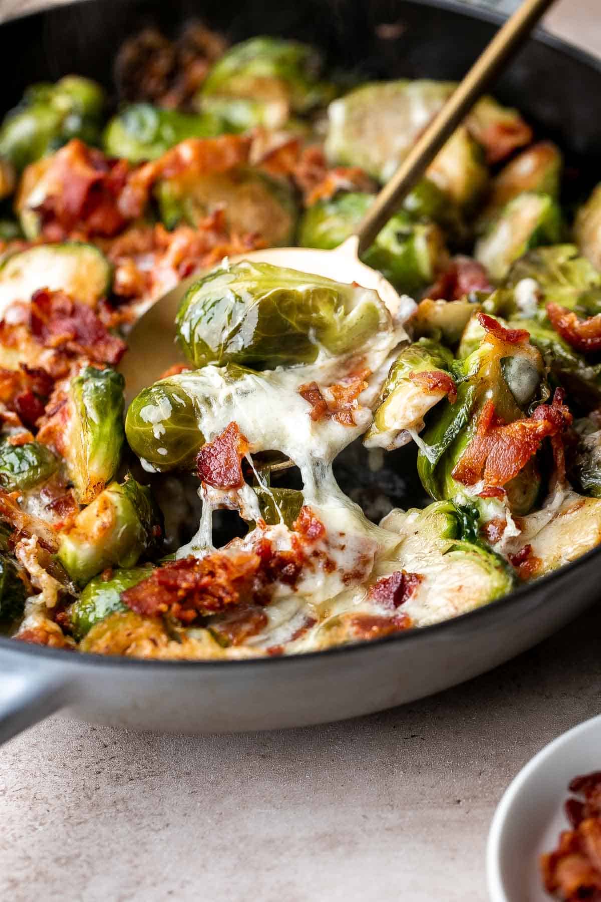 Cheesy Brussels Sprouts Bake is a comforting side dish made with sautéed garlic brussels sprouts, topped with bacon and cheese, and baked until bubbly. | aheadofthyme.com