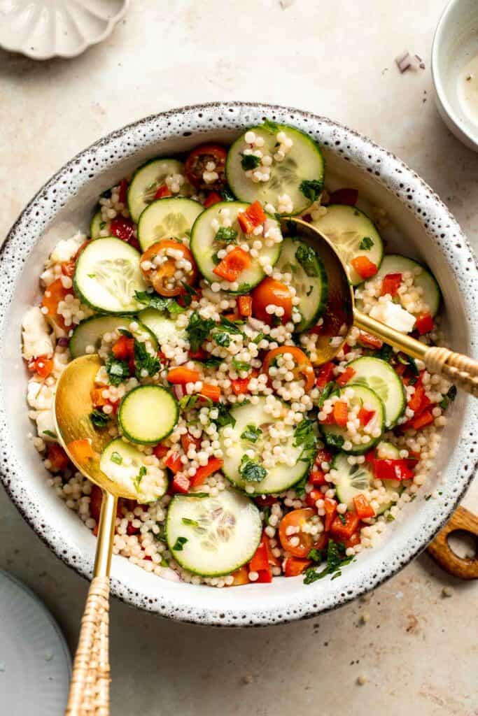 Israeli Couscous Salad is a hearty, flavorful, and delicious salad, packed with pearl couscous, fresh veggies, and feta, tossed in a simple lemon dressing. | aheadofthyme.com