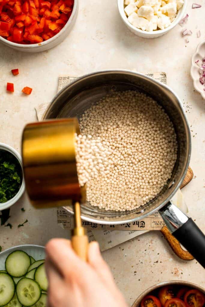 Israeli Couscous Salad is a hearty, flavorful, and delicious salad, packed with pearl couscous, fresh veggies, and feta, tossed in a simple lemon dressing. | aheadofthyme.com