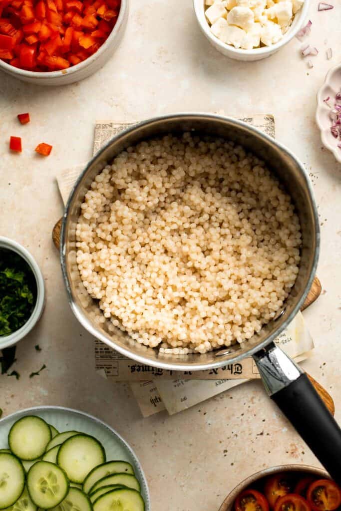 Israeli Couscous Salad is a hearty, flavorful, and delicious salad, packed with pearl couscous, fresh veggies, and feta, tossed in a simple lemon dressing. | aheadofthyme.com