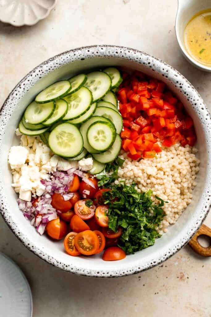 Israeli Couscous Salad is a hearty, flavorful, and delicious salad, packed with pearl couscous, fresh veggies, and feta, tossed in a simple lemon dressing. | aheadofthyme.com