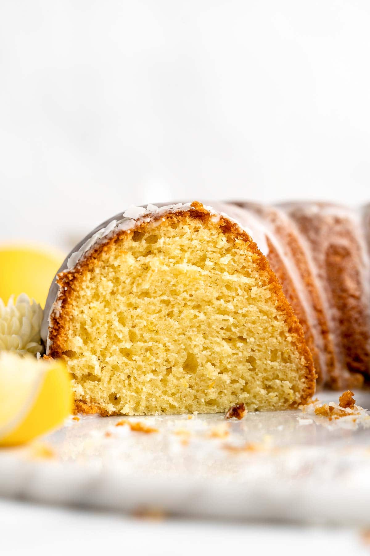 Lemon Bundt Cake with a sweet vanilla glaze is light, fluffy, and moist with a perfect golden brown crumb and made with real lemons. | aheadofthyme.com