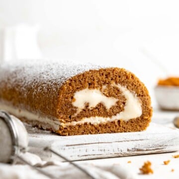 Celebrate the flavors of fall with a show-stopping Pumpkin Roll featuring a tender pumpkin spice cake swirled around a rich cream cheese filling. | aheadofthyme.com