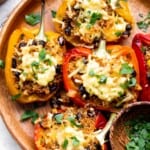 Vegetarian Stuffed Peppers are hearty, flavorful, and easy to make. They are loaded with quinoa, black beans, and corn and topped with gooey melted cheese. | aheadofthyme.com