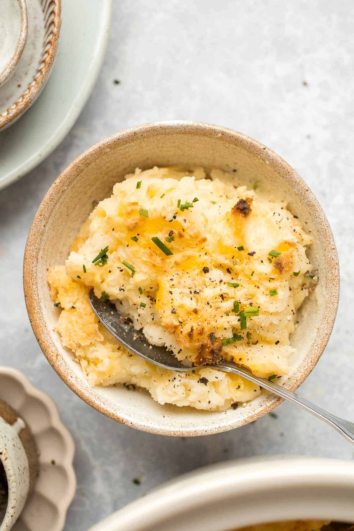 Baked Mashed Potatoes are buttery, cheesy, and crispy on the outside. Topped with chives and served warm, this side dish that will change your hosting game. | aheadofthyme.com