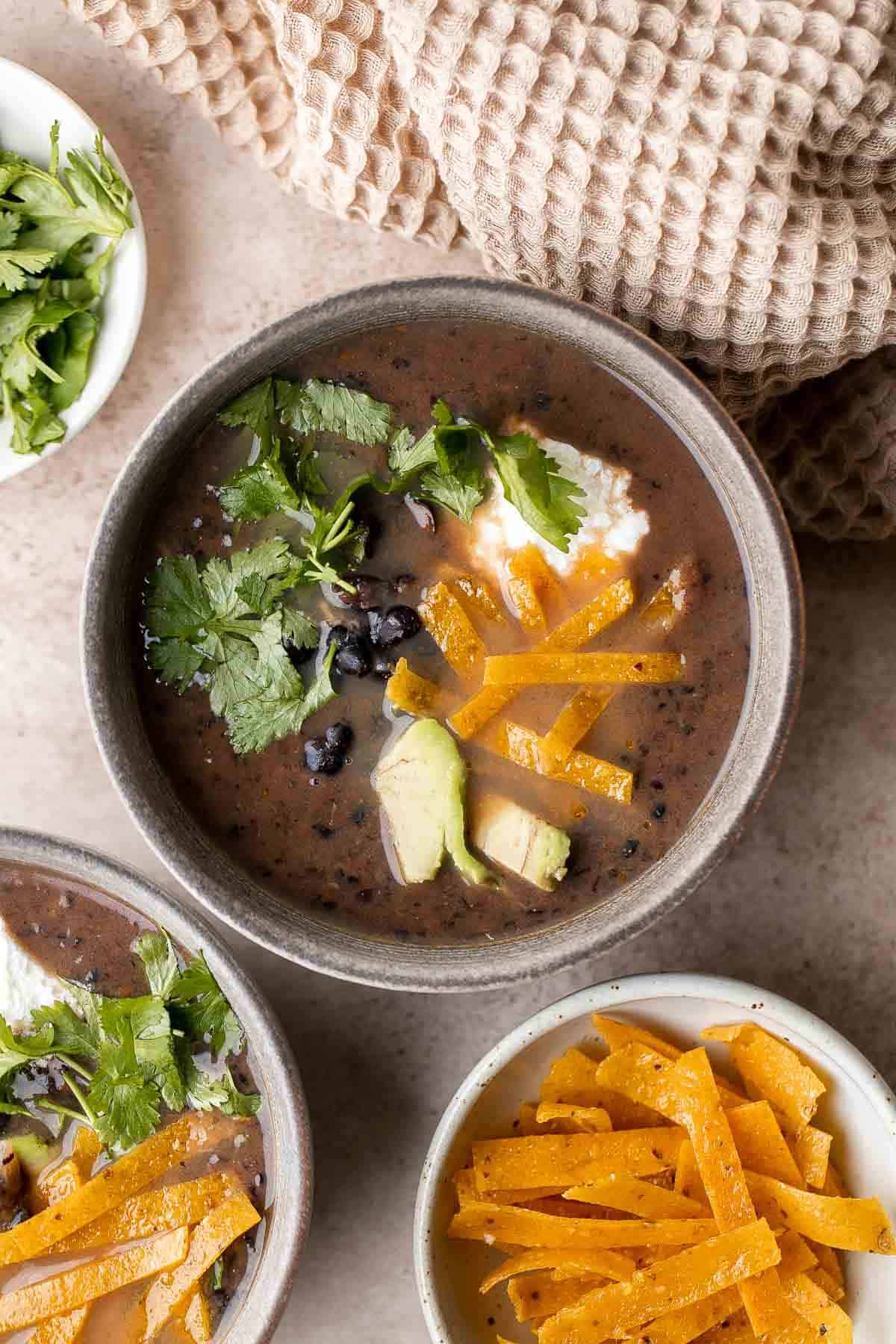 This Black Bean Soup is hearty, healthy, and cozy — everything you want in a soup! It's loaded with black beans, spices, and your favorite Mexican toppings. | aheadofthyme.com