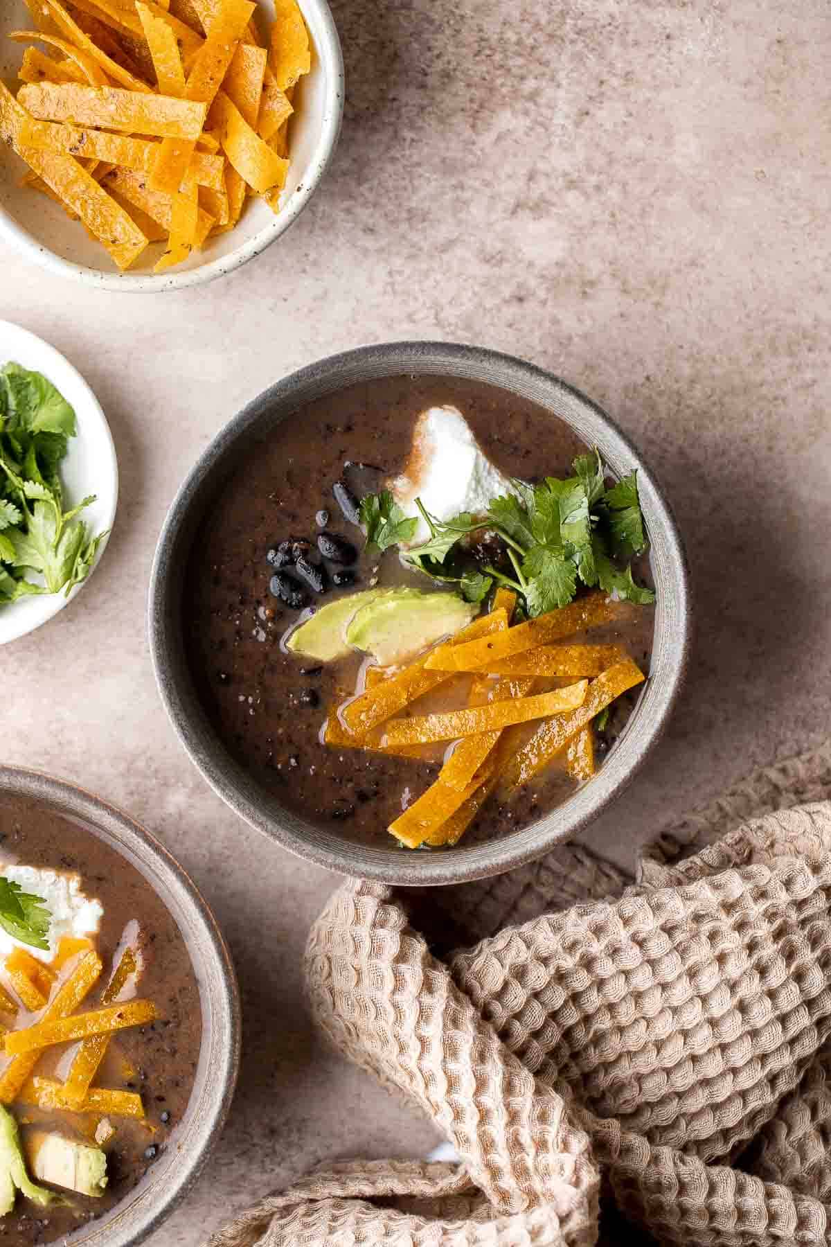 This Black Bean Soup is hearty, healthy, and cozy — everything you want in a soup! It's loaded with black beans, spices, and your favorite Mexican toppings. | aheadofthyme.com