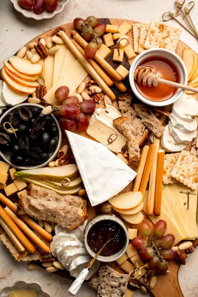 This easy Cheese Board is a popular and classic appetizer arranged with an assortment of cheese, bread and crackers, fresh fruit, and nuts. | aheadofthyme.com