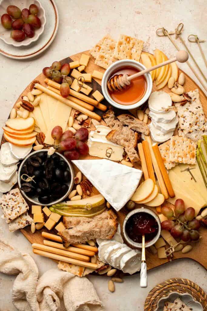 This easy Cheese Board is a popular and classic appetizer arranged with an assortment of cheese, bread and crackers, fresh fruit, and nuts. | aheadofthyme.com