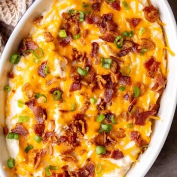 This Mashed Potato Casserole elevates an ordinary batch of creamy mashed potatoes into something divine topped with cheddar, bacon bits, and green onions. | aheadofthyme.com