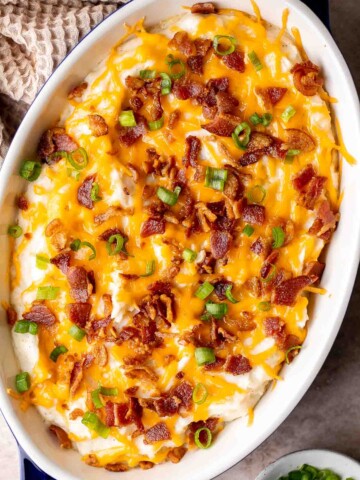 This Mashed Potato Casserole elevates an ordinary batch of creamy mashed potatoes into something divine topped with cheddar, bacon bits, and green onions. | aheadofthyme.com