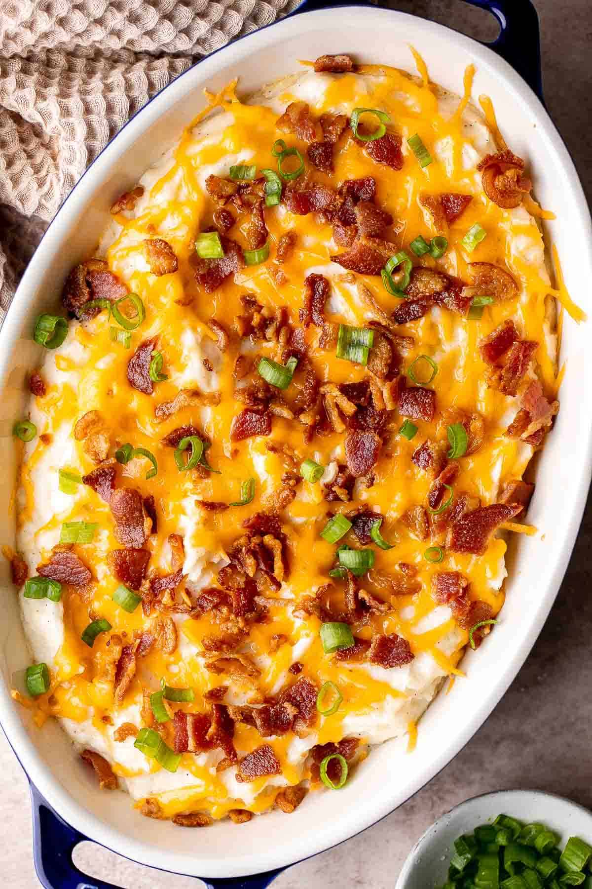 This Mashed Potato Casserole elevates an ordinary batch of creamy mashed potatoes into something divine topped with cheddar, bacon bits, and green onions. | aheadofthyme.com