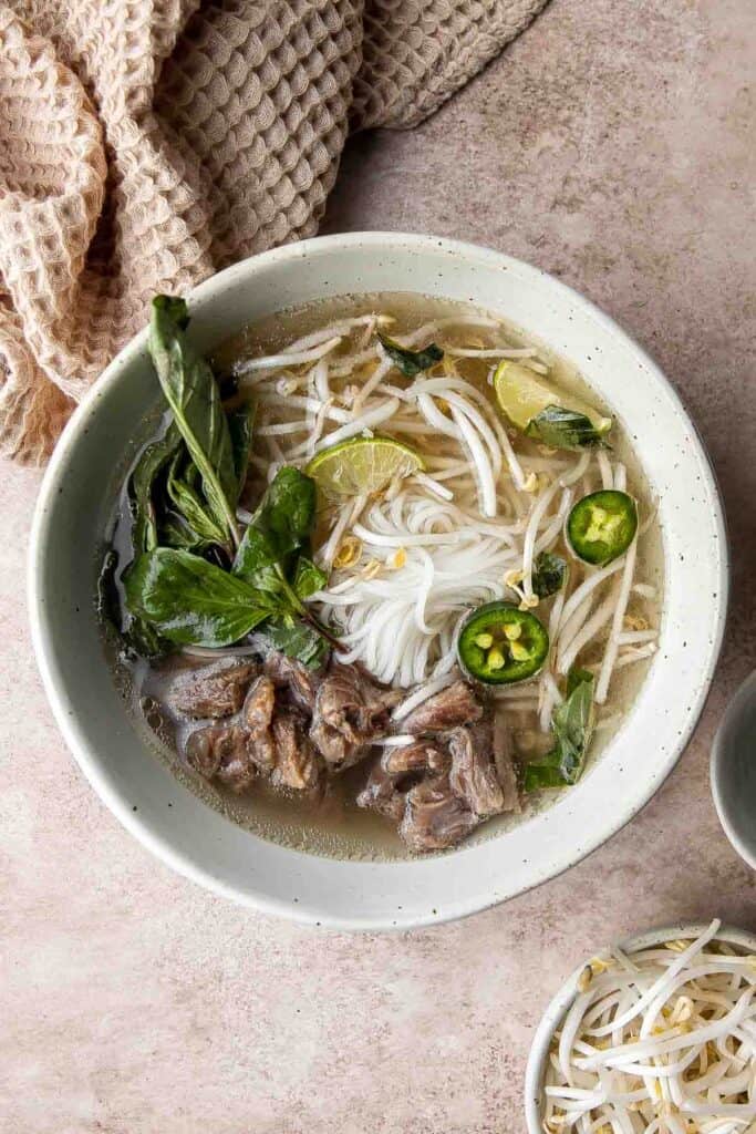 Vietnamese Pho is a one-of-a-kind soup known for its aromatic beef broth served over tender rice noodles, beef sirloin, fresh herbs, and other garnishes. | aheadofthyme.com