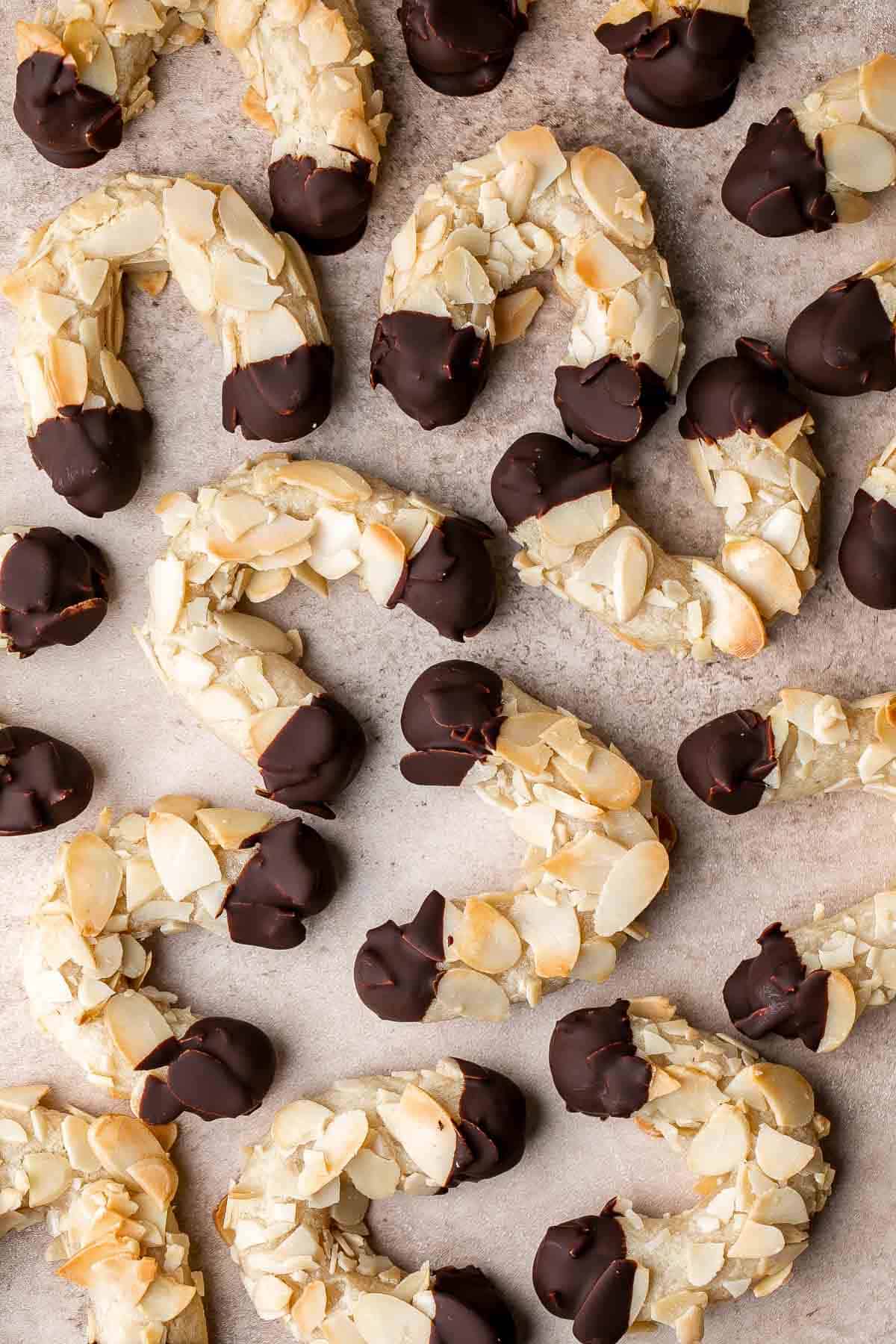 Almond Horns are chewy, horseshoe-shaped crescent cookies covered in crunchy almonds and dipped in chocolate, inspired by the classic German Mandelhörnchen. | aheadofthyme.com