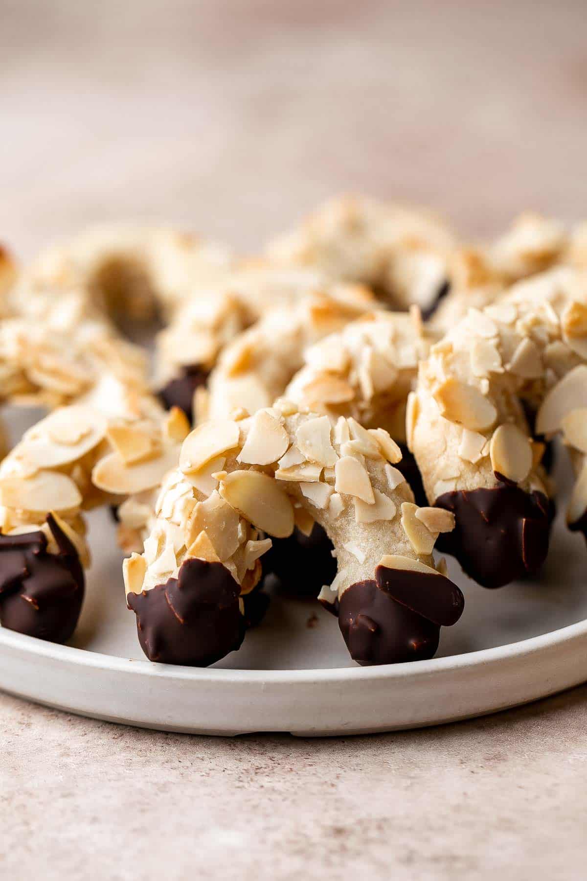 Almond Horns are chewy, horseshoe-shaped crescent cookies covered in crunchy almonds and dipped in chocolate, inspired by the classic German Mandelhörnchen. | aheadofthyme.com