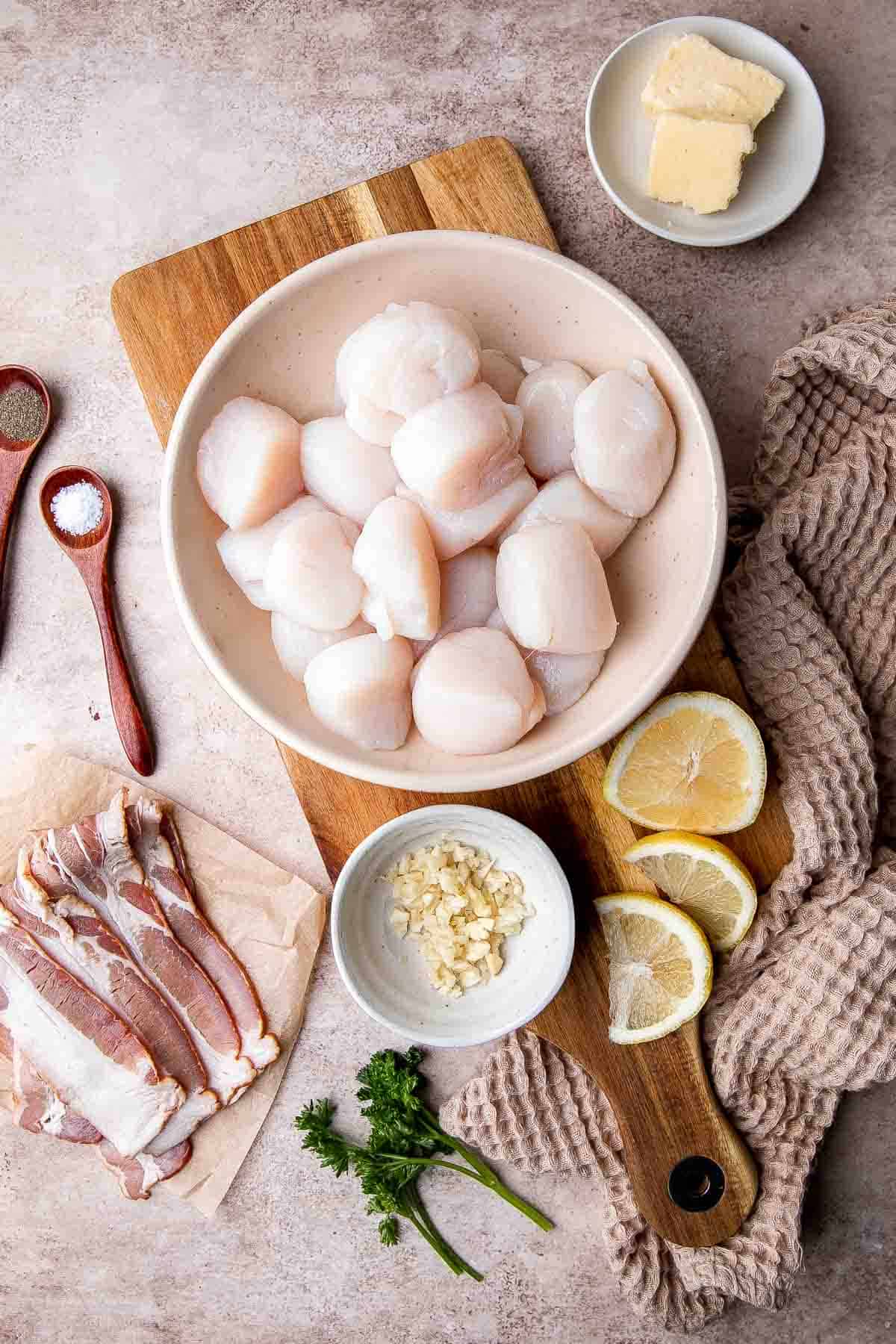 Bacon Wrapped Scallops are the most decadent appetizer to serve at your next part. Tender, fresh scallops are wrapped in bacon slices before baked. | aheadofthyme.com