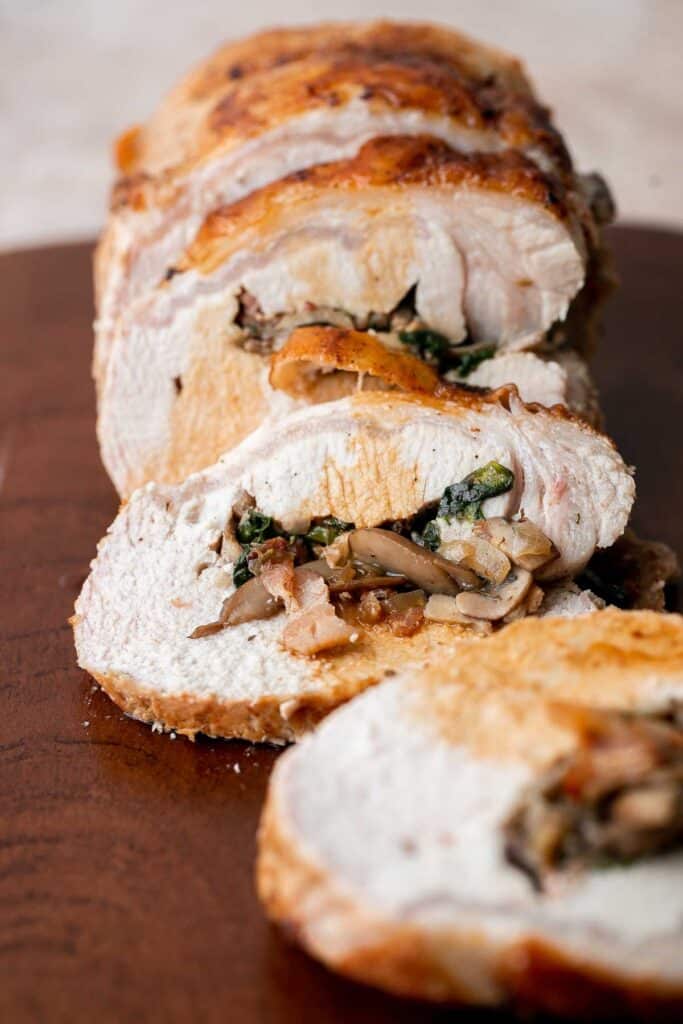 This juicy tender Stuffed Pork Loin filled with a delicious mushroom and spinach stuffing is a gorgeous entree to serve at your next dinner party. | aheadofthyme.com