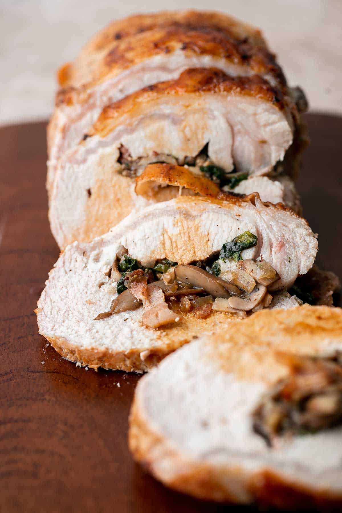 This juicy tender Stuffed Pork Loin filled with a delicious mushroom and spinach stuffing is a gorgeous entree to serve at your next dinner party. | aheadofthyme.com