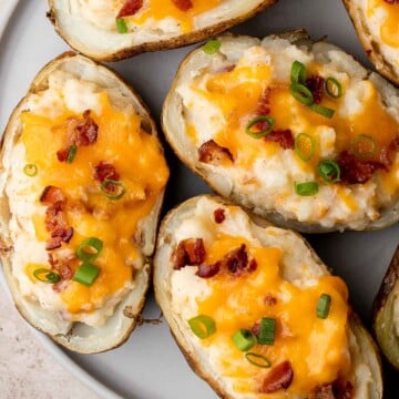 Twice Baked Potatoes are the perfect side dish or appetizer with tender baked potato boats, gooey, cheesy filling, and classic baked potato toppings. | aheadofthyme.com