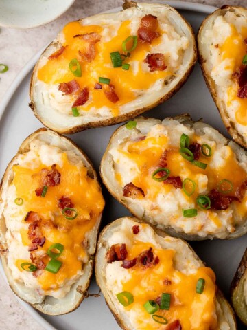 Twice Baked Potatoes are the perfect side dish or appetizer with tender baked potato boats, gooey, cheesy filling, and classic baked potato toppings. | aheadofthyme.com