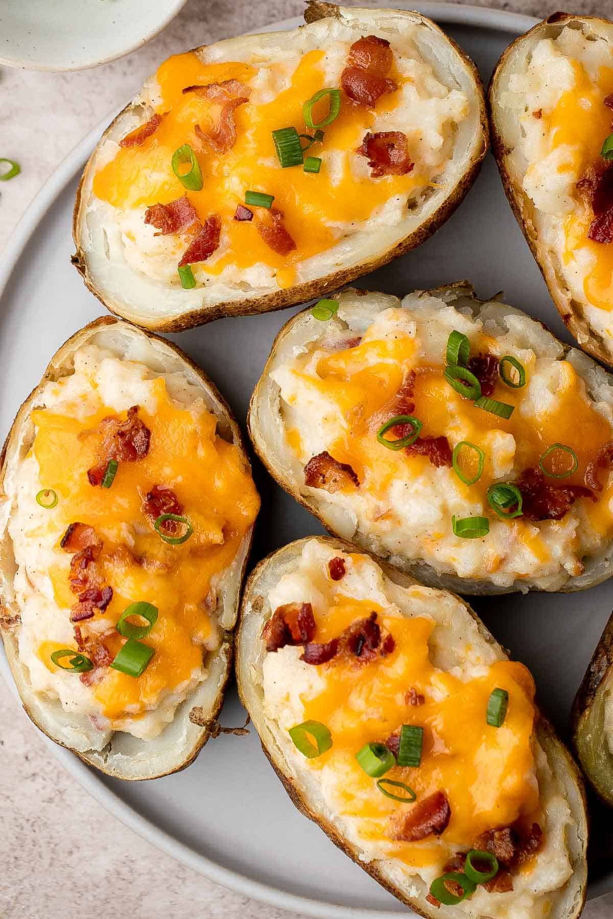 Twice Baked Potatoes are the perfect side dish or appetizer with tender baked potato boats, gooey, cheesy filling, and classic baked potato toppings. | aheadofthyme.com