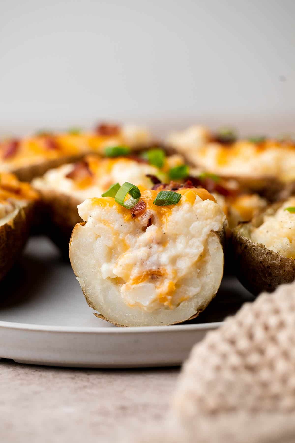 Twice Baked Potatoes are the perfect side dish or appetizer with tender baked potato boats, gooey, cheesy filling, and classic baked potato toppings. | aheadofthyme.com