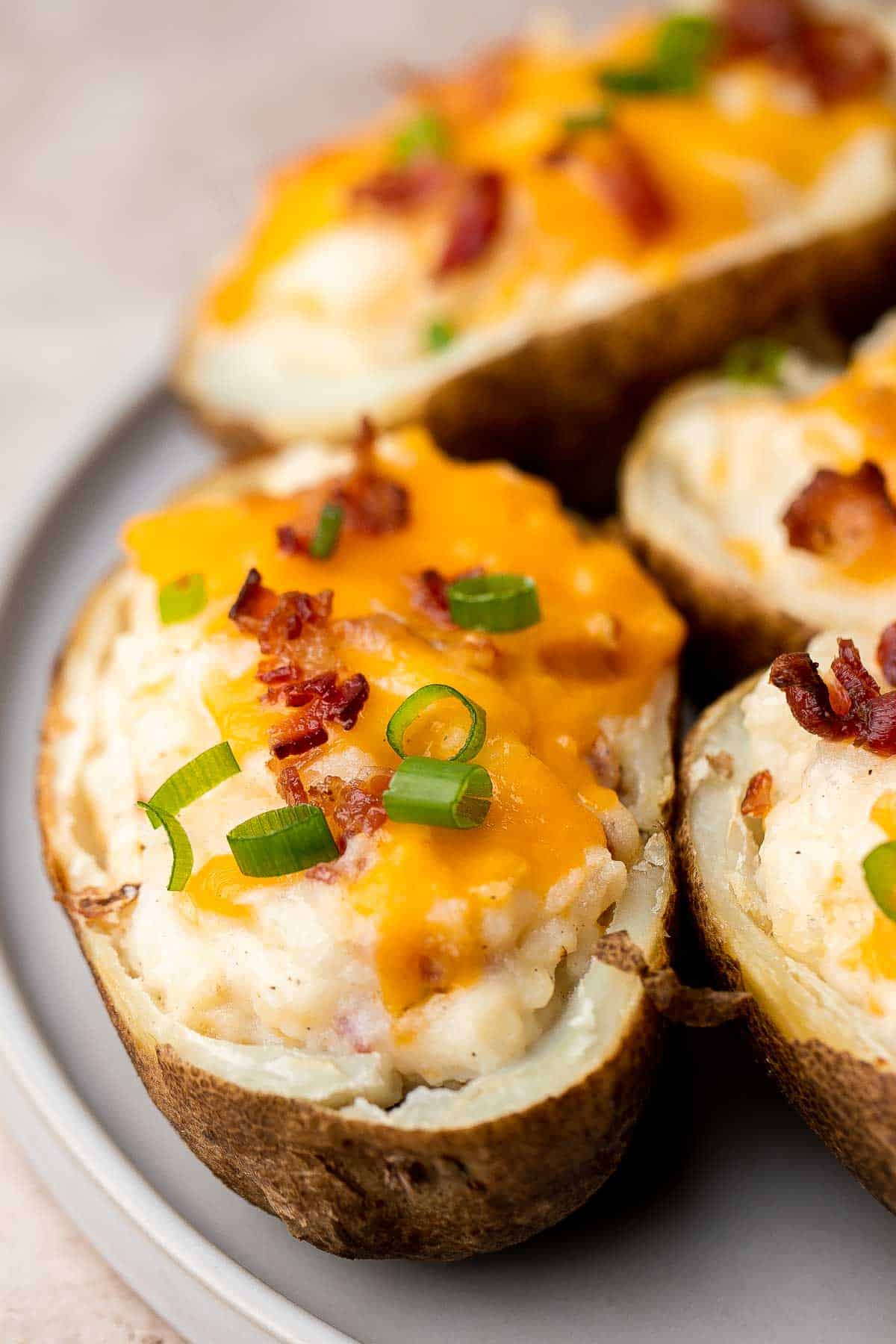 Twice Baked Potatoes are the perfect side dish or appetizer with tender baked potato boats, gooey, cheesy filling, and classic baked potato toppings. | aheadofthyme.com