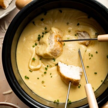 This Swiss Cheese Fondue with warm, melty cheese is a classic. Serve it as a quick and easy appetizer or dinner with bread, potatoes, and more. | aheadofthyme.com