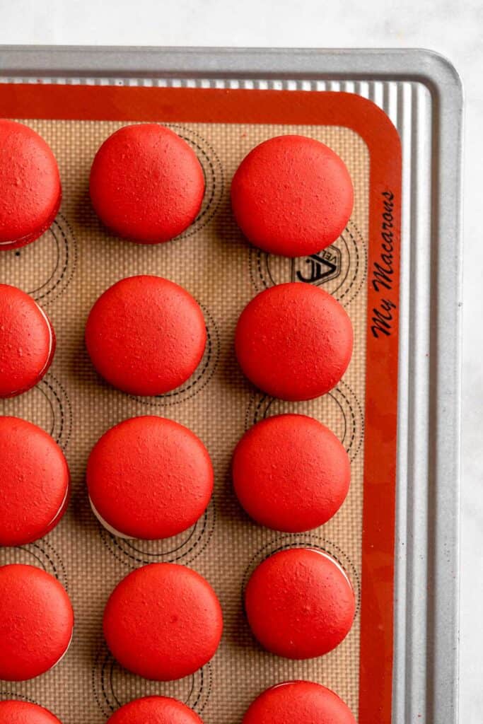 These homemade Red Velvet Macarons with cream cheese frosting are like the beloved cake but in bite-sized form — bold red color and a hint of cocoa flavor. | aheadofthyme.com