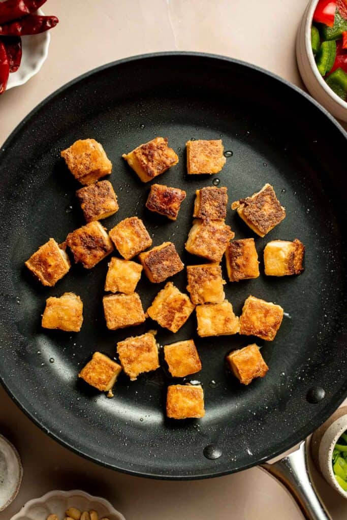 This homemade Kung Pao Tofu, made with perfectly crispy pan-fried tofu tossed in the most delicious sauce with peppers and onions is ready in 25 minutes. | aheadofthyme.com