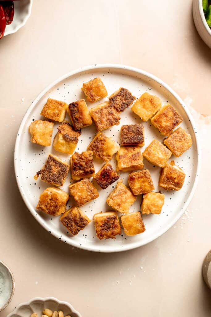 This homemade Kung Pao Tofu, made with perfectly crispy pan-fried tofu tossed in the most delicious sauce with peppers and onions is ready in 25 minutes. | aheadofthyme.com