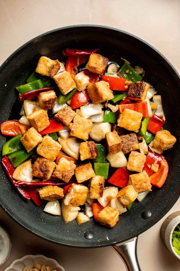 This homemade Kung Pao Tofu, made with perfectly crispy pan-fried tofu tossed in the most delicious sauce with peppers and onions is ready in 25 minutes. | aheadofthyme.com