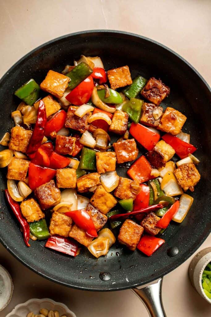 This homemade Kung Pao Tofu, made with perfectly crispy pan-fried tofu tossed in the most delicious sauce with peppers and onions is ready in 25 minutes. | aheadofthyme.com