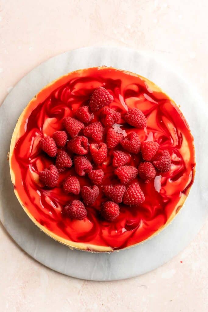 This White Chocolate Raspberry Cheesecake is so decadent, made with a creamy white chocolate cheesecake batter swirled with homemade raspberry sauce. | aheadofthyme.com