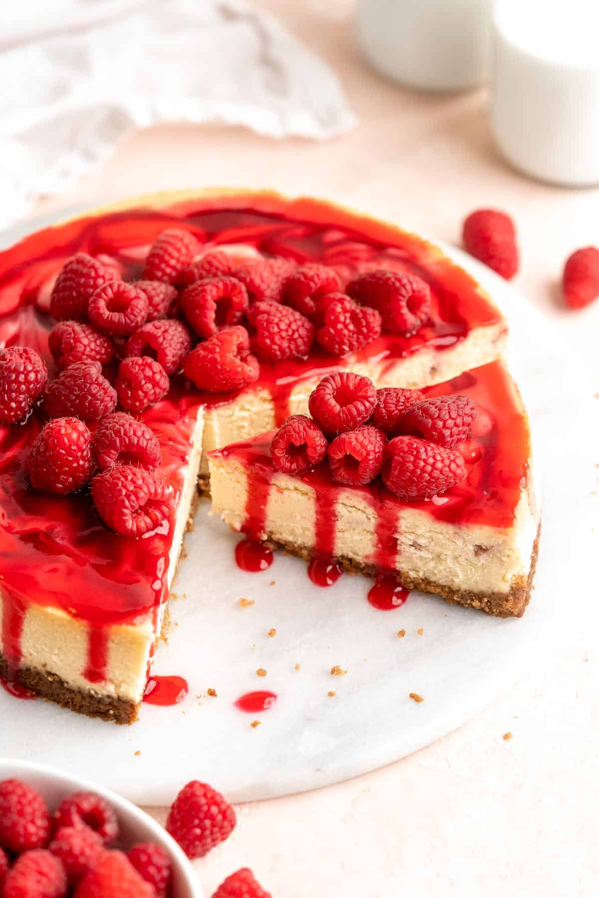 This White Chocolate Raspberry Cheesecake is so decadent, made with a creamy white chocolate cheesecake batter swirled with homemade raspberry sauce. | aheadofthyme.com