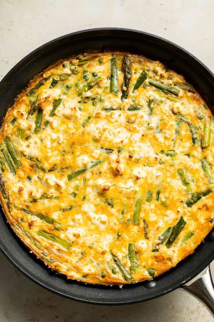 This Asparagus Frittata, made with sautéed asparagus and peas baked with eggs and creamy feta cheese, is perfect for your next spring brunch! | aheadofthyme.com