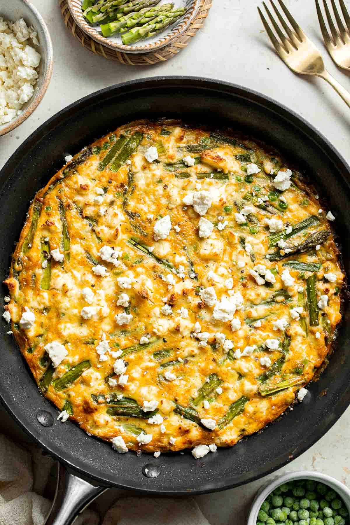 This Asparagus Frittata, made with sautéed asparagus and peas baked with eggs and creamy feta cheese, is perfect for your next spring brunch! | aheadofthyme.com