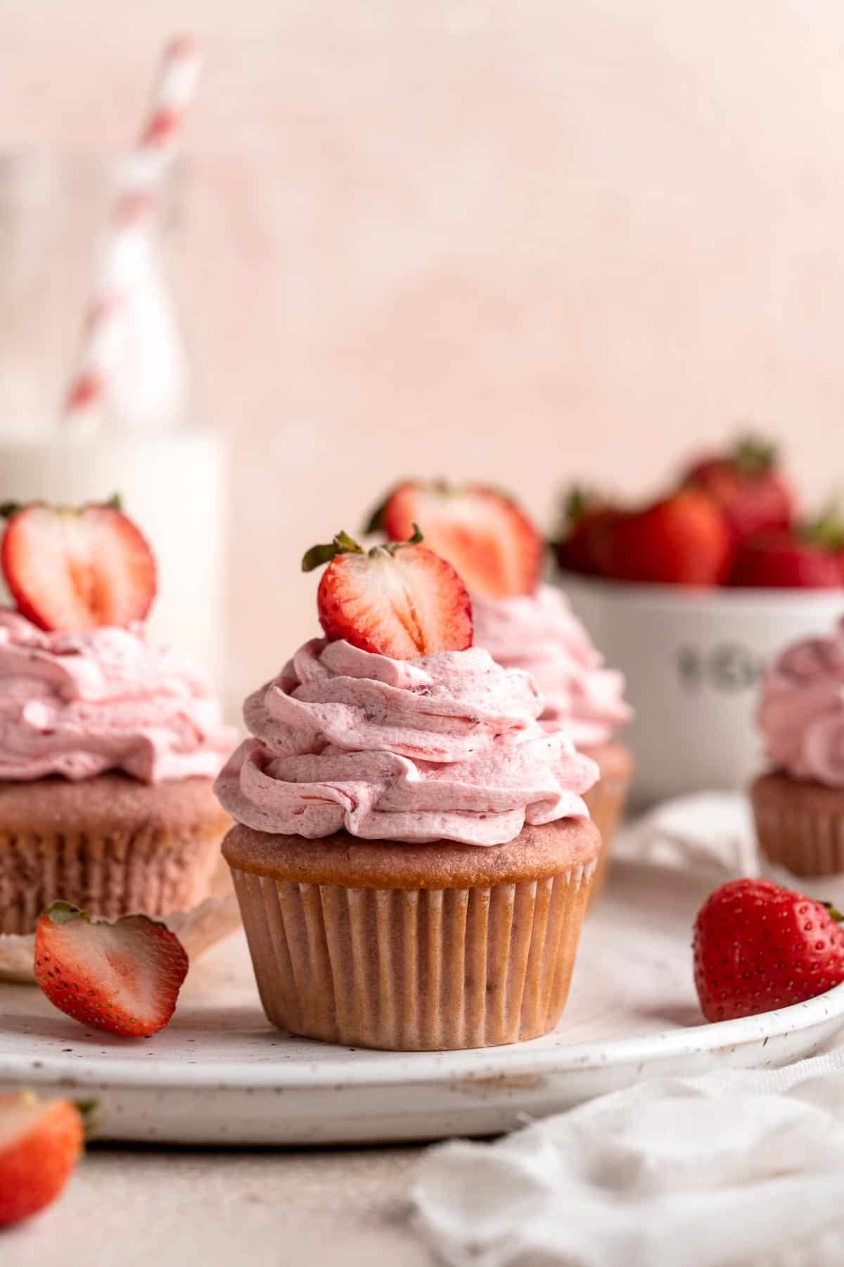 Strawberry Cupcakes are made with real strawberries in both the tender cake batter and the creamy strawberry buttercream frosting. A picture-perfect treat! | aheadofthyme.com