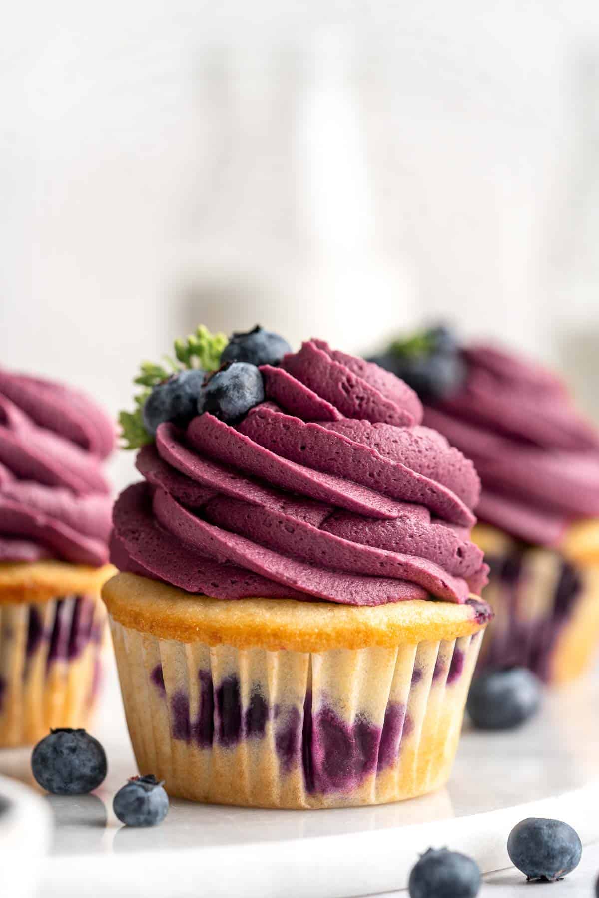 Blueberry Cupcakes are a homemade treat with moist and tender vanilla cupcake batter loaded with fresh blueberries and topped with blueberry buttercream. | aheadofthyme.com