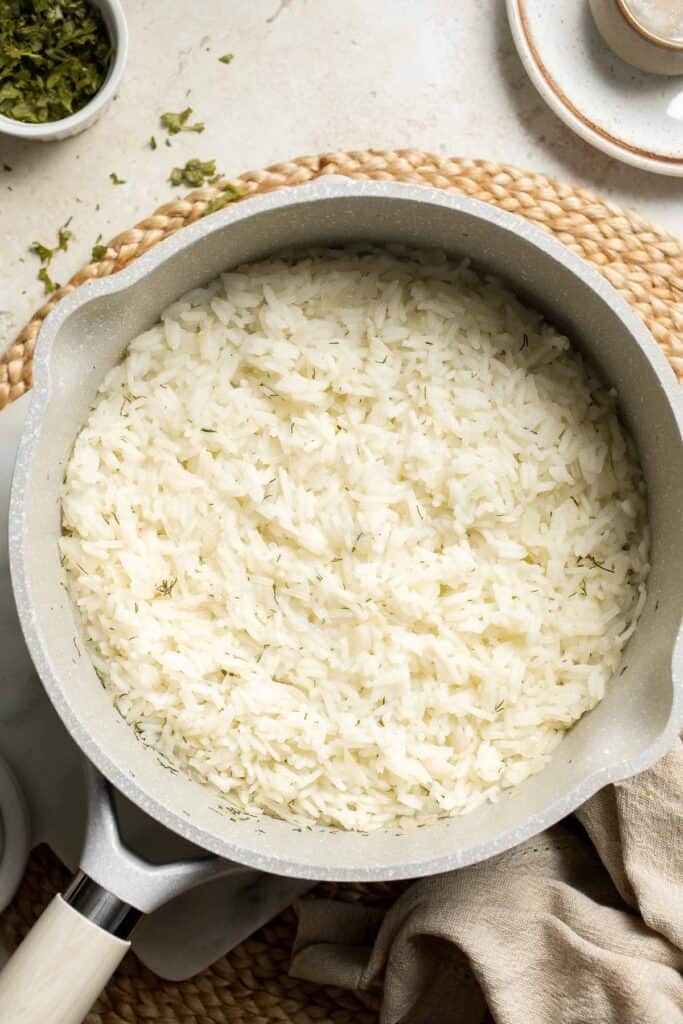 This simple Greek Rice is lemony, full of herbs, and warm, delicious flavors — and it couldn't be much easier to make. Our go-to fluffy herb rice dish! | aheadofthyme.com