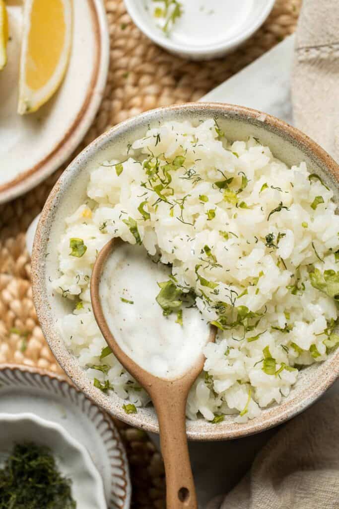 This simple Greek Rice is lemony, full of herbs, and warm, delicious flavors — and it couldn't be much easier to make. Our go-to fluffy herb rice dish! | aheadofthyme.com