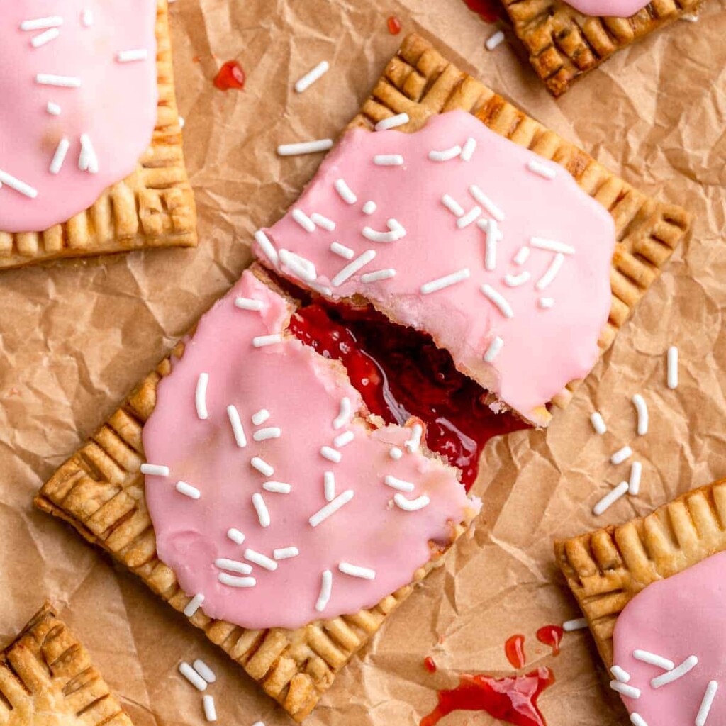 These Homemade Pop Tarts buttery, flaky, and filled with sweet strawberry jam with a pink vanilla glaze on top - a major upgrade on the store-bought kind! | aheadofthyme.com