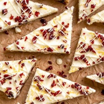 Skip the trip to Starbucks and make homemade Cranberry Bliss Bars instead with a blondie base with dried cranberries and topped with cream cheese frosting. | aheadofthyme.com