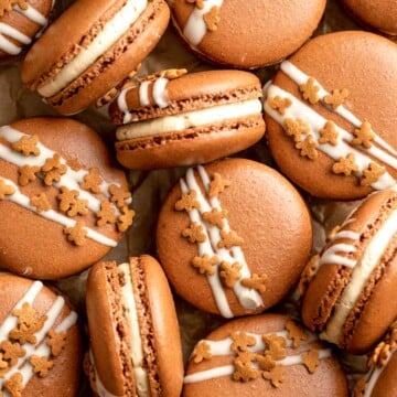 Gingerbread Macarons with spiced gingerbread shells, molasses buttercream, and white chocolate and cookie topping are a festive bite-sized treat. | aheadofthyme.com