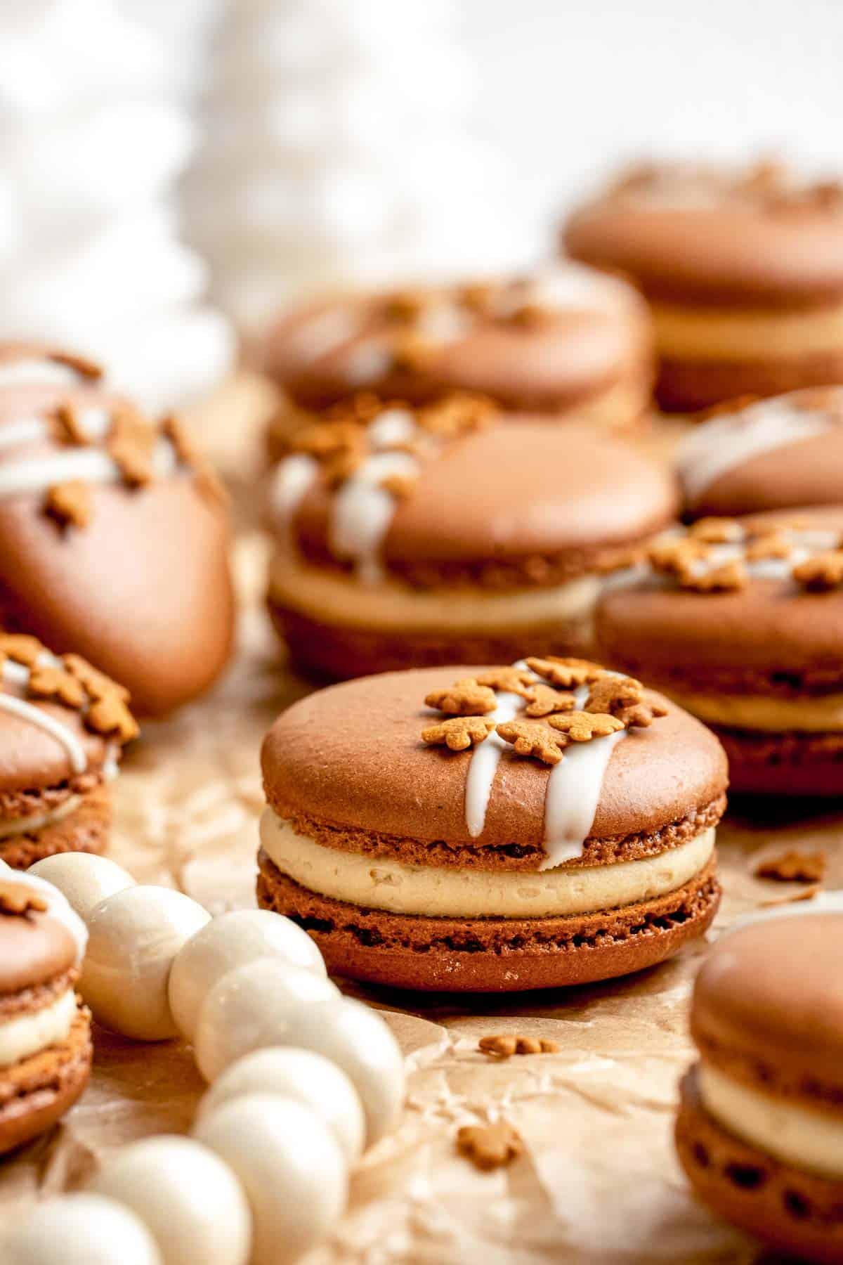 Gingerbread Macarons with spiced gingerbread shells, molasses buttercream, and white chocolate and cookie topping are a festive bite-sized treat. | aheadofthyme.com