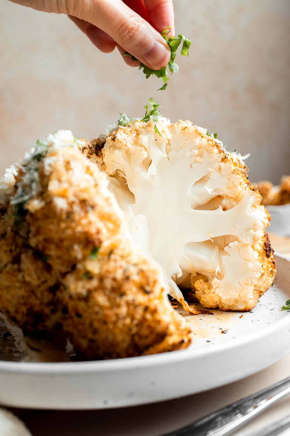 Whole Roasted Cauliflower features a flavorful crust and tender, buttery florets. It is a stunning vegetarian centerpiece that is easy to prepare. | aheadofthyme.com