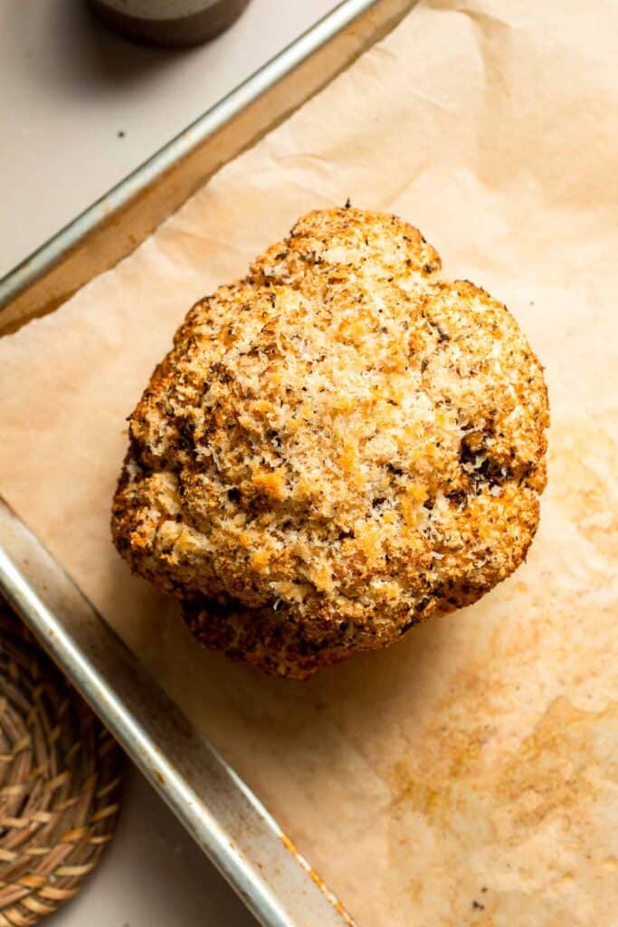 Whole Roasted Cauliflower features a flavorful crust and tender, buttery florets. It is a stunning vegetarian centerpiece that is easy to prepare. | aheadofthyme.com