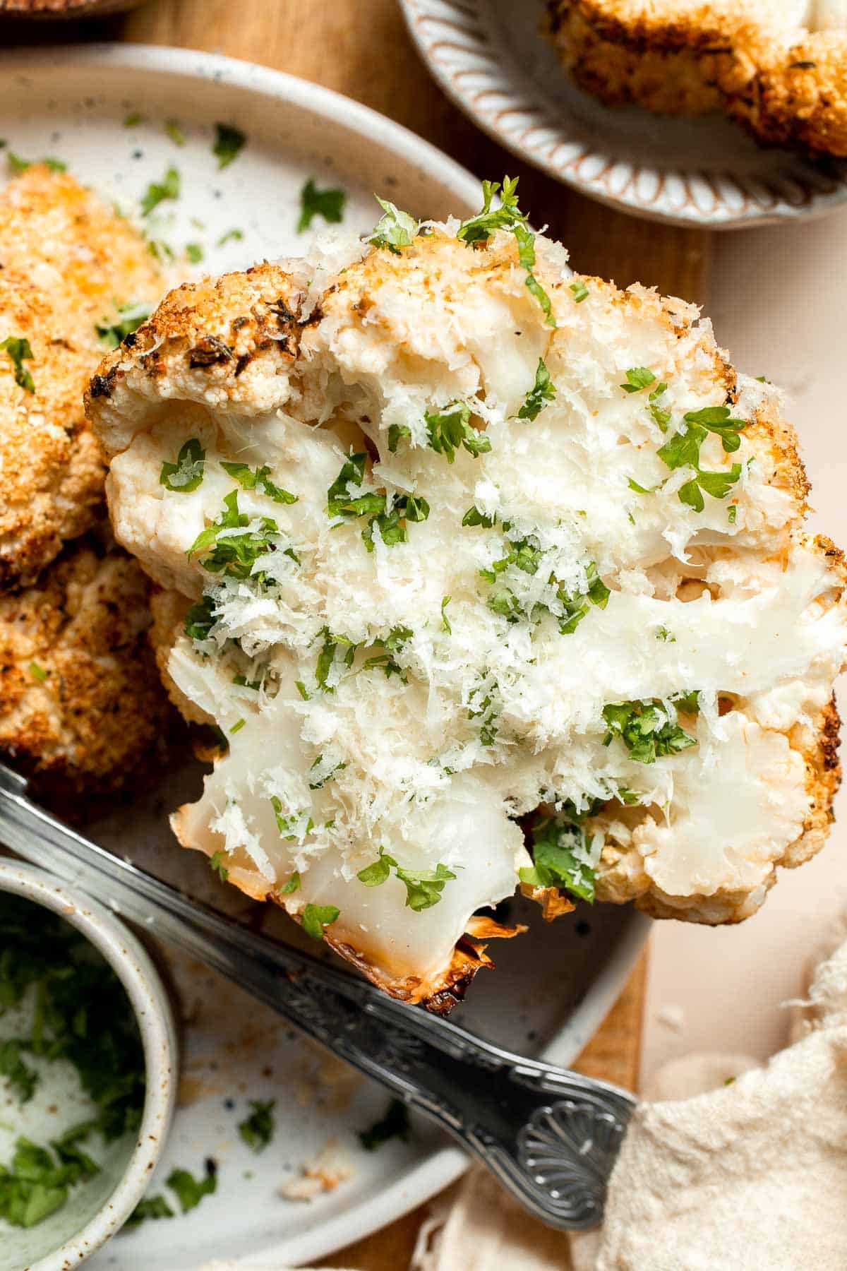 Whole Roasted Cauliflower features a flavorful crust and tender, buttery florets. It is a stunning vegetarian centerpiece that is easy to prepare. | aheadofthyme.com